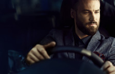 Close-up of a  handsome young businessman driving a car