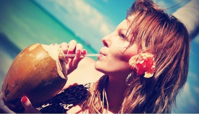 woman drinking from coconut