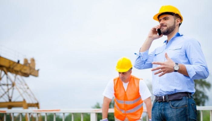 construction worker and manager talking on the phone