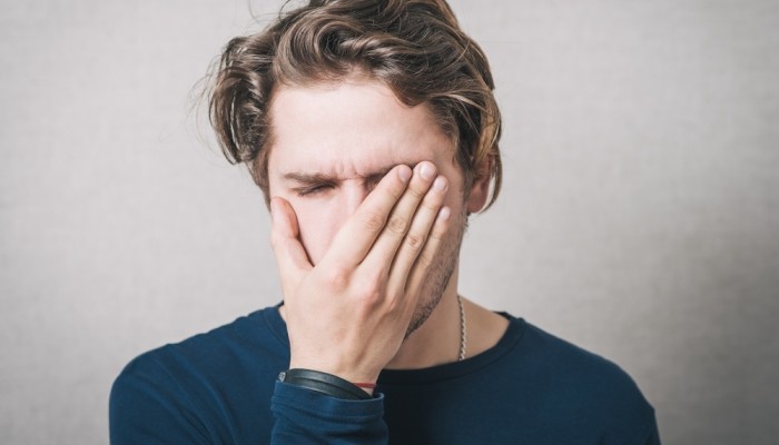 man crying covered his face with his hands