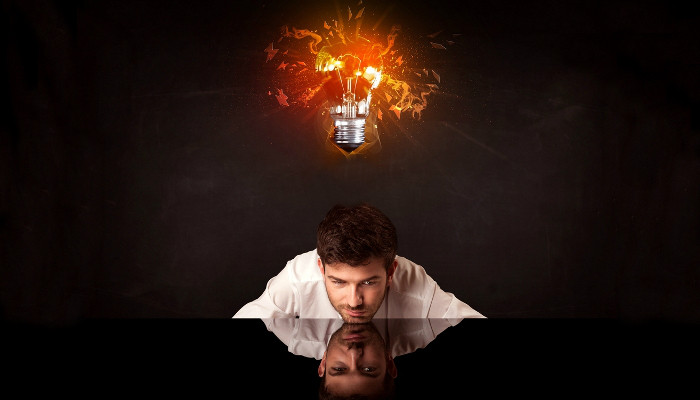 Man sitting under light bulb