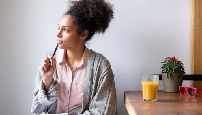 woman thinking holding a pen