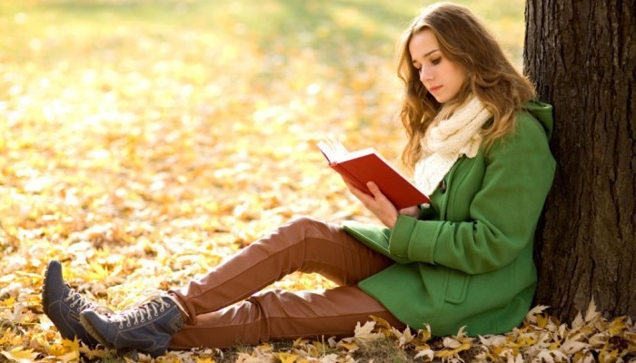 girl reading a book under tree