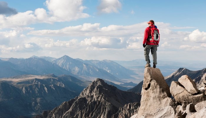 man standing at the edge of hill