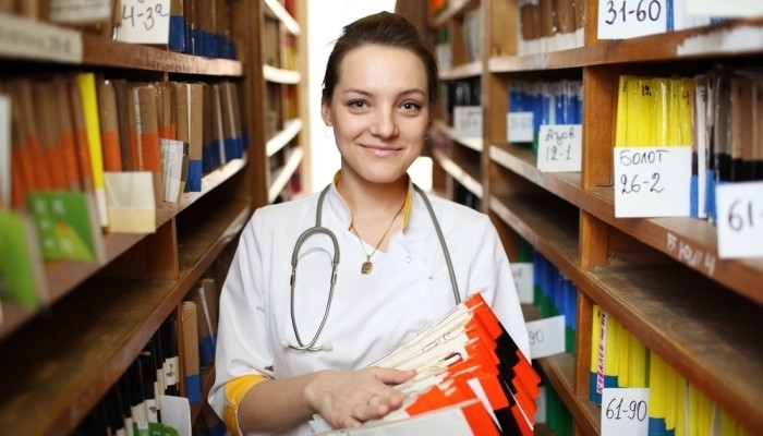Doctor standing in aisle of medical records