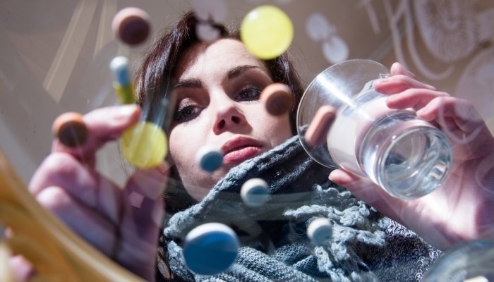 Girl looking at colorful pills