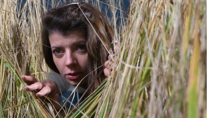 young woman hiding in high weed