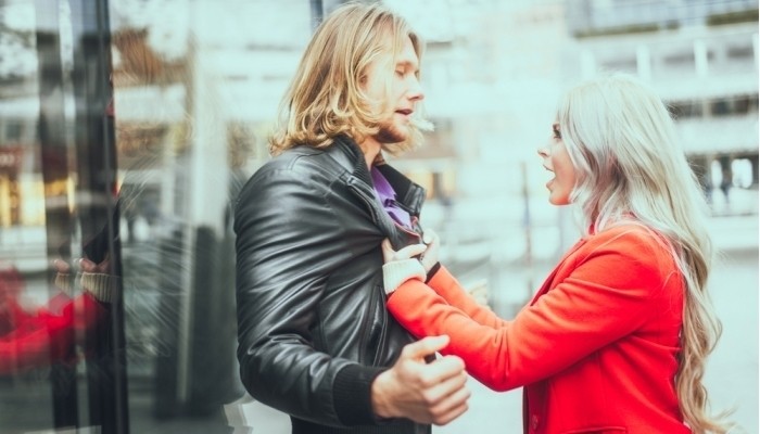 woman grabbing her boyfriend and shouting