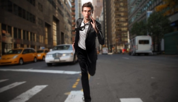 Businessman running down street