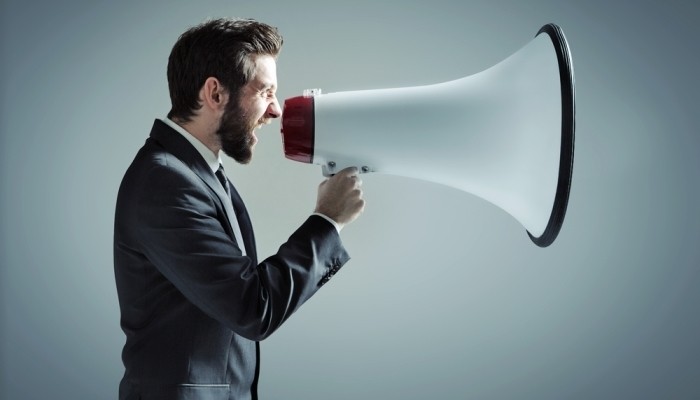 Businessman shouting into large megaphone