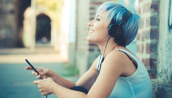 Blue-haired woman listening to music