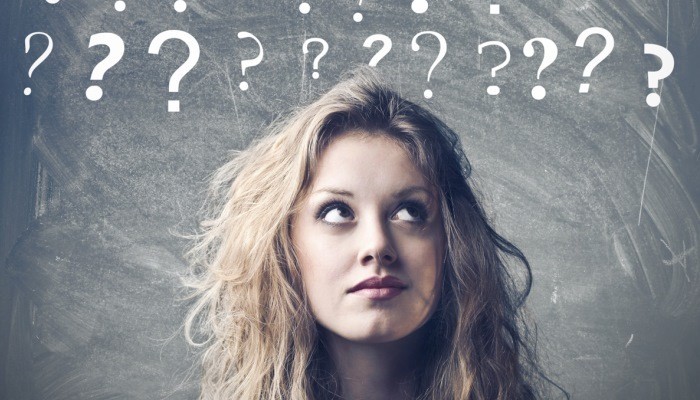 Young woman surrounded by question marks