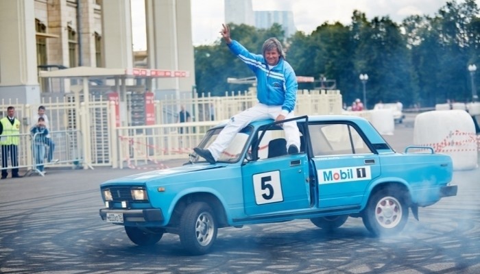 stunt driver sitting on top of car
