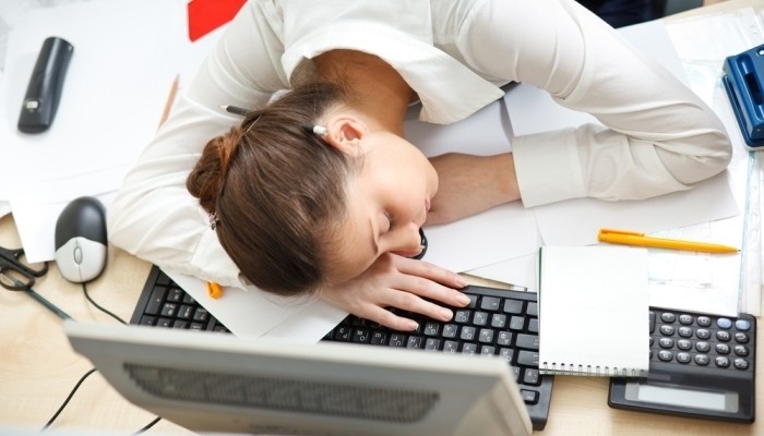Young woman sleeping at desk