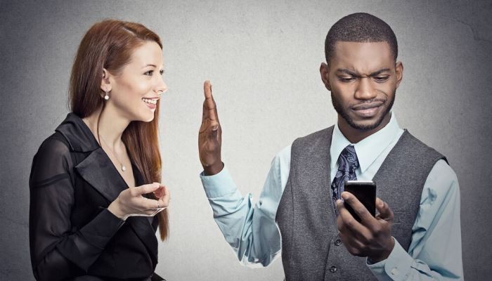 Man placing hand in front of woman
