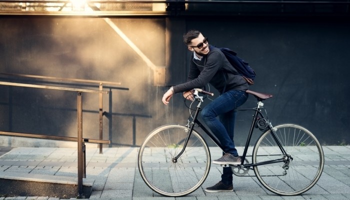 A young stylish businessman going to work by bike