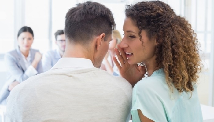 businesswoman telling a secret to colleague in the office