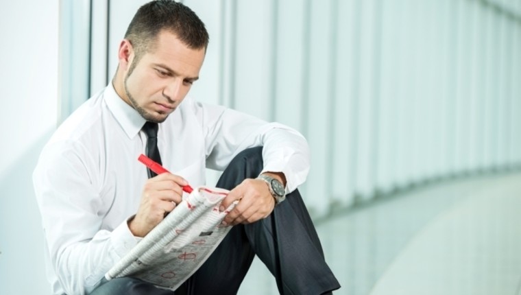 man looking for job in newspaper