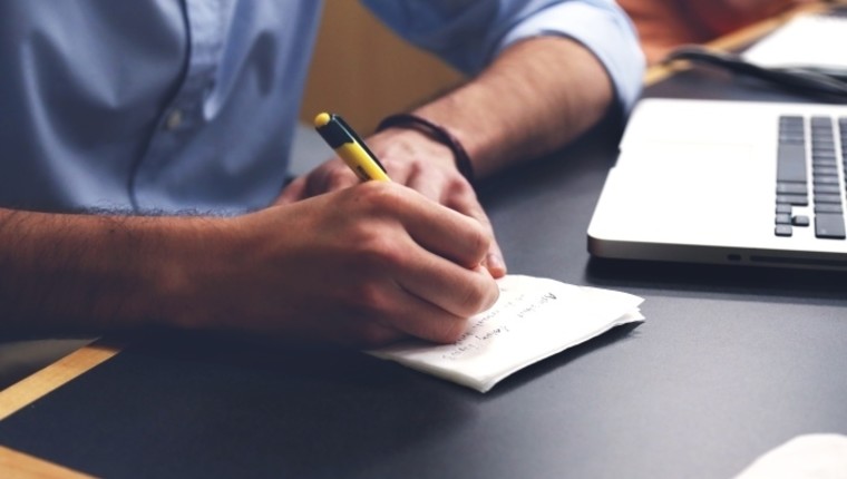 man writing notes