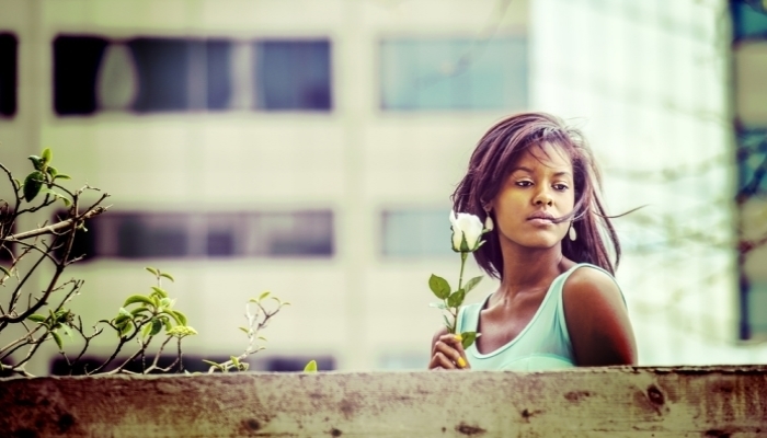 black woman holding white rose