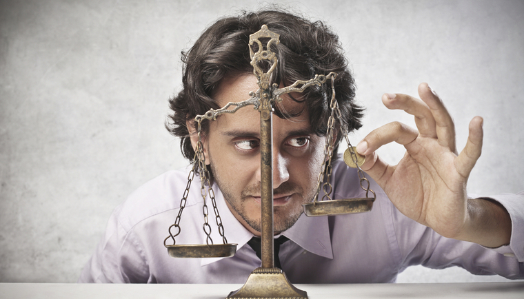 Businessman placing coin on scales