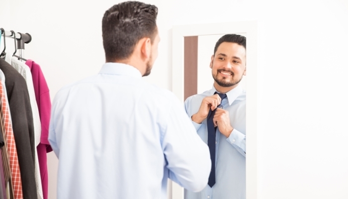 Handsome young man getting dressed