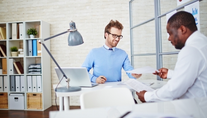 man handing cv to hiring manager