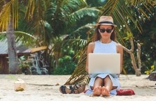 freelancer woman using laptop on sunny beach