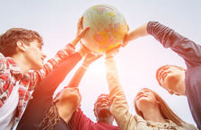 Group of multiracial teenagers holding globe