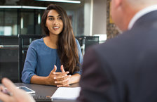 Smiling young woman attending a job interview with an older male HR manager