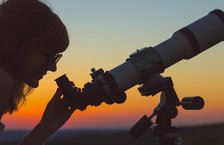 Astronomer looking at the sky through an astronomical telescope